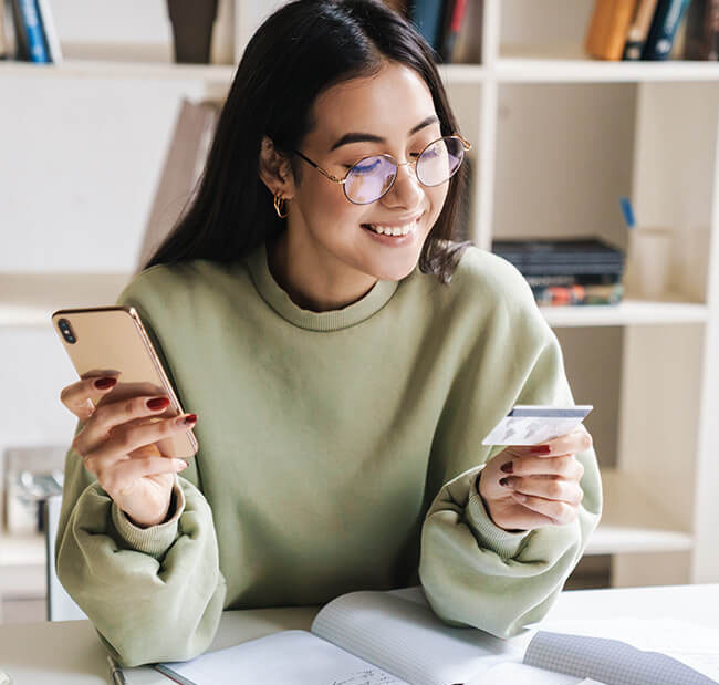 Woman in green sweatshirt making changes on her account on her phone