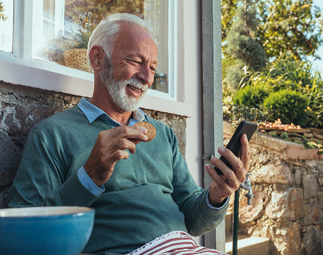 Retired man enjoying DCTFCU online banking from his mobile device